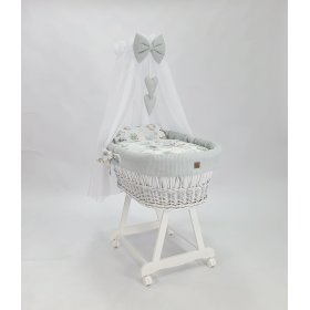 Weißes Korbbett mit Ausstattung für ein Baby – Igel